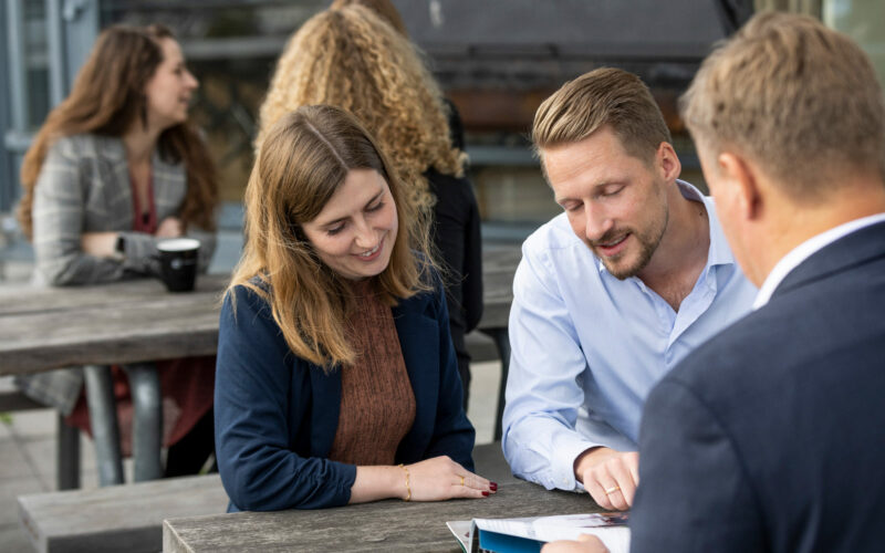 Image of consultants sitting at a table and talking outside