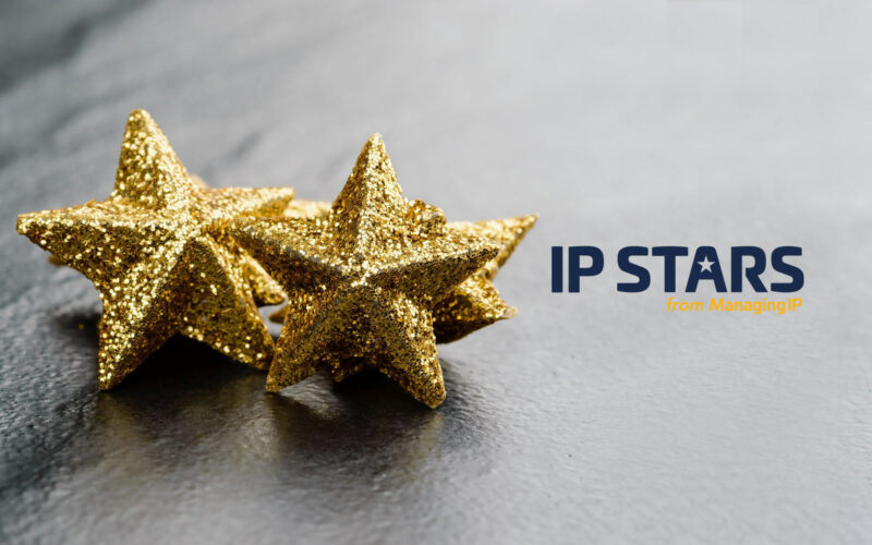 Gold stars on light grey background and IP Stars-logo